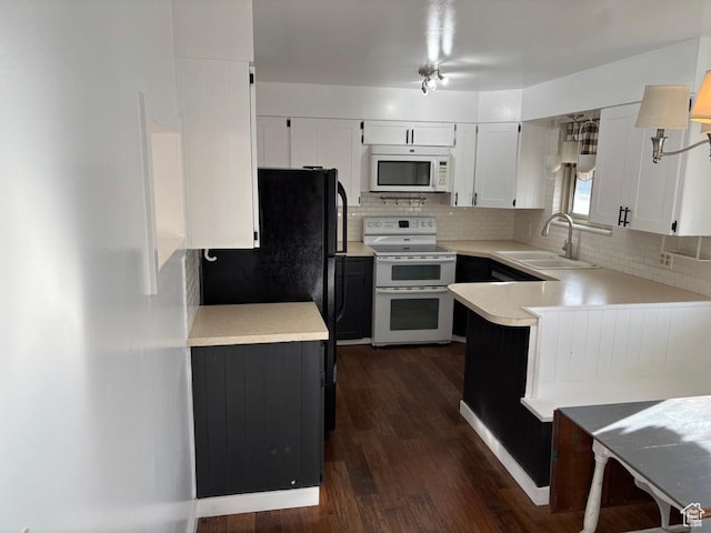 kitchen with white microwave, backsplash, light countertops, range with two ovens, and a sink