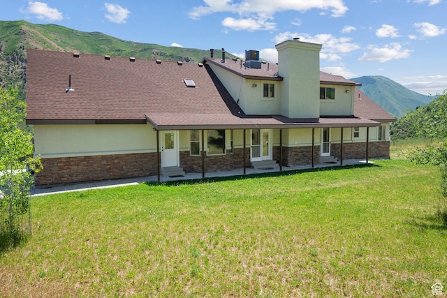 1762 S Hobblecreek Haven Rd, Springville, UT 84663 - back of property featuring stone siding, a mountain view, a lawn, and stucco siding