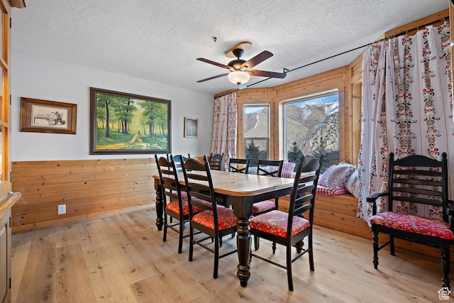 1762 S Hobblecreek Haven Rd, Springville, UT 84663 - dining area featuring a textured ceiling, light wood finished floors, wooden walls, and a ceiling fan