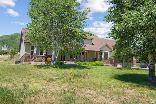 1762 S Hobblecreek Haven Rd, Springville, UT 84663 - obstructed view of property with stone siding, covered porch, a front yard, and a mountain view