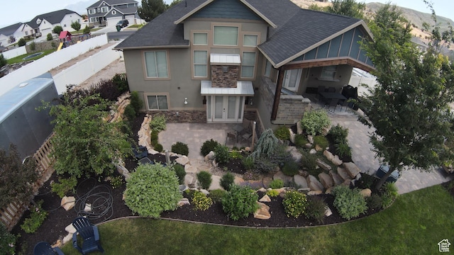 13862 S 7300 W, Herriman, UT 84096 - view of front facade with stone siding, a patio, stucco siding, a shingled roof, and a residential view