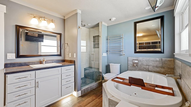 bathroom with a stall shower, vanity, wood finished floors, radiator, and a bath