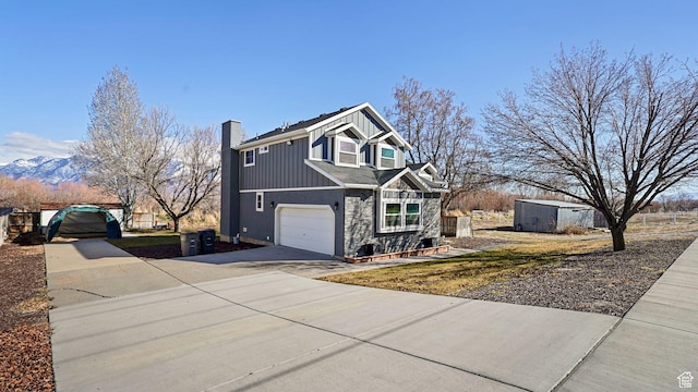 view of front of house with board and batten siding, driveway, an attached garage, and a chimney