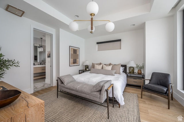 864 W Sapphire Sky Ln Unit 546, St George, UT 84790 - bedroom featuring light wood finished floors, ensuite bath, and a tray ceiling