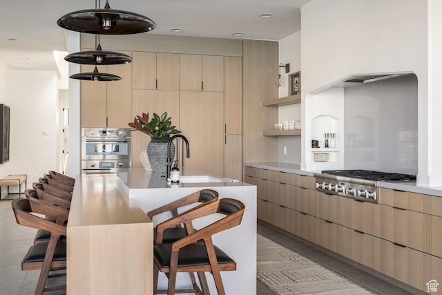 864 W Sapphire Sky Ln Unit 546, St George, UT 84790 - kitchen with light brown cabinetry, stainless steel appliances, a kitchen bar, and a sink
