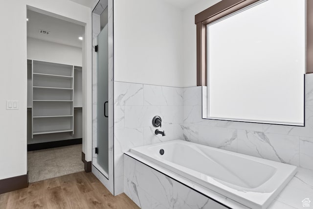 810 E 150 S, Enterprise, UT 84725 - bathroom featuring wood finished floors, a garden tub, a shower stall, and a walk in closet