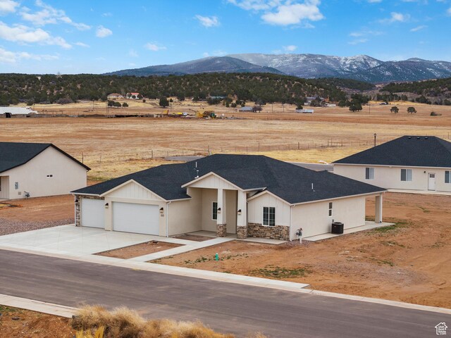810 E 150 S, Enterprise, UT 84725 - view of front of property with stone siding, a mountain view, an attached garage, and driveway