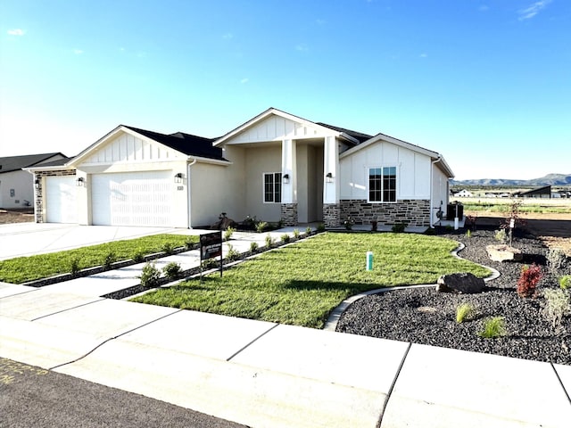 810 E 150 S, Enterprise, UT 84725 - view of front of home featuring board and batten siding, a garage, a front yard, stone siding, and concrete driveway