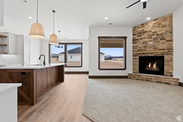 810 E 150 S, Enterprise, UT 84725 - kitchen featuring open shelves, light countertops, ceiling fan, a fireplace, and hanging light fixtures