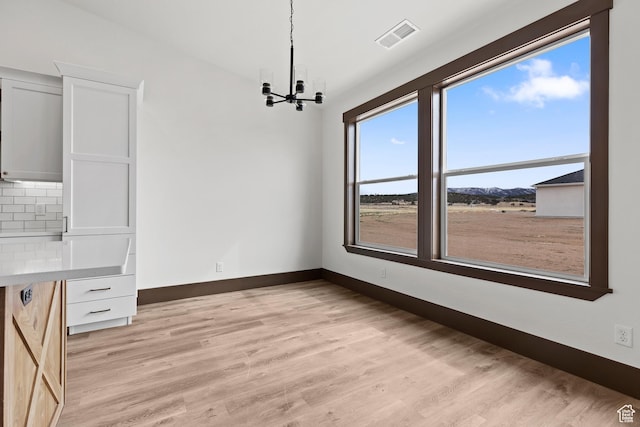 810 E 150 S, Enterprise, UT 84725 - unfurnished dining area featuring light wood-style flooring, a chandelier, and baseboards