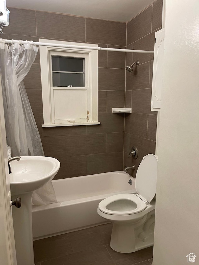 bathroom featuring toilet and shower / tub combo with curtain