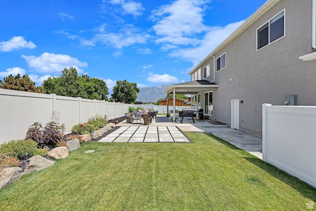 view of yard with ceiling fan, a mountain view, a patio, and a fenced backyard