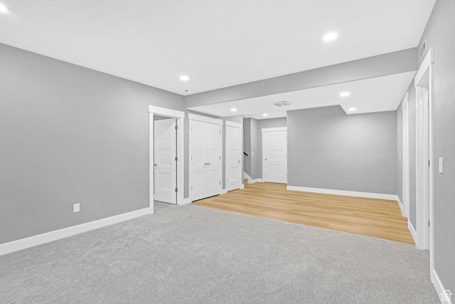 basement featuring recessed lighting, stairway, baseboards, and light colored carpet