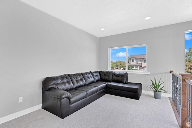 carpeted living area with recessed lighting, visible vents, and baseboards