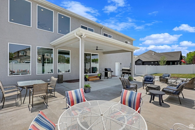 view of patio featuring a grill, outdoor dining space, a ceiling fan, and fence