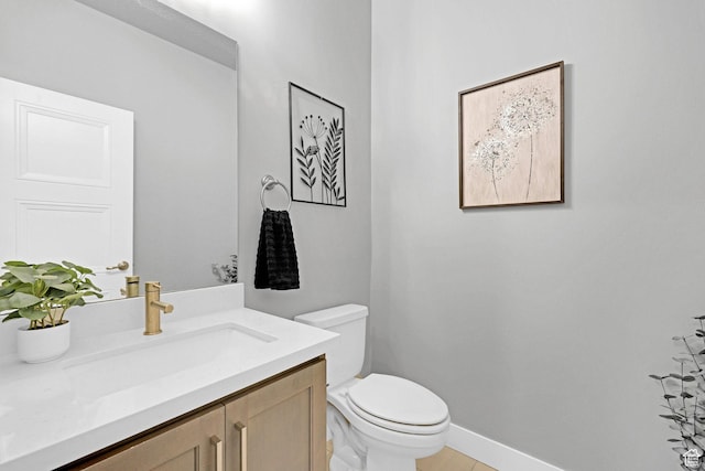 bathroom featuring vanity, toilet, and baseboards