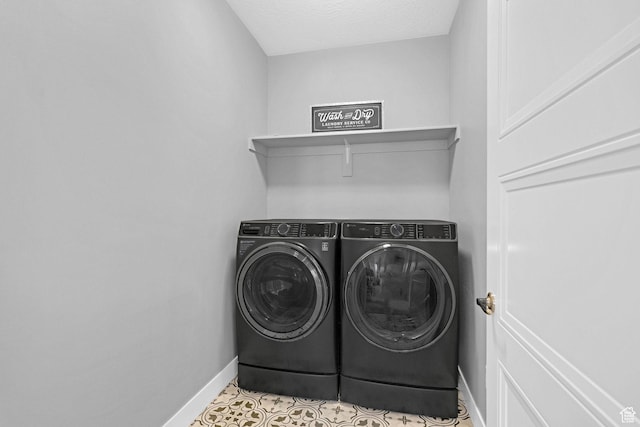 laundry area with tile patterned flooring, laundry area, washing machine and dryer, and baseboards