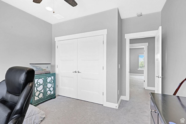 home office with baseboards, light carpet, and a ceiling fan