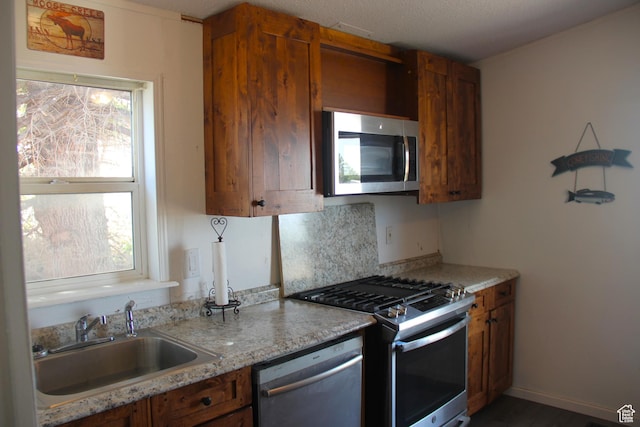 3223 S Nina Loop, Garden City, UT 84028 - kitchen with a sink, brown cabinets, a wealth of natural light, and stainless steel appliances