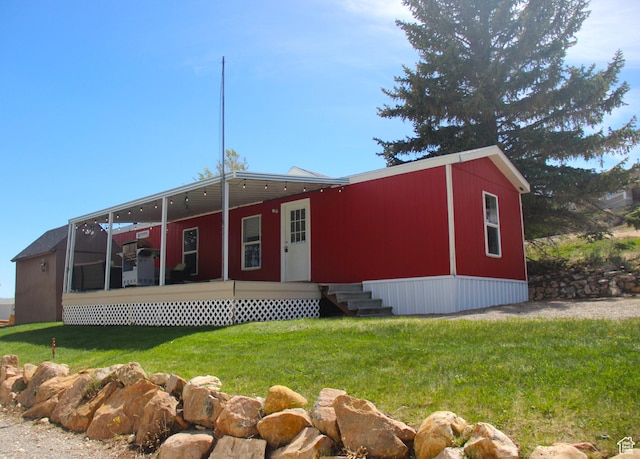 manufactured / mobile home featuring a sunroom, a front lawn, and entry steps