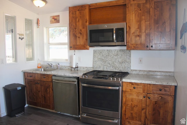 3223 S Nina Loop, Garden City, UT 84028 - kitchen with a sink, tasteful backsplash, stainless steel appliances, brown cabinetry, and dark wood-style flooring