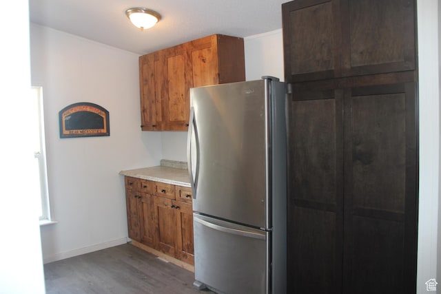 3223 S Nina Loop, Garden City, UT 84028 - kitchen with wood finished floors, baseboards, freestanding refrigerator, light countertops, and brown cabinets