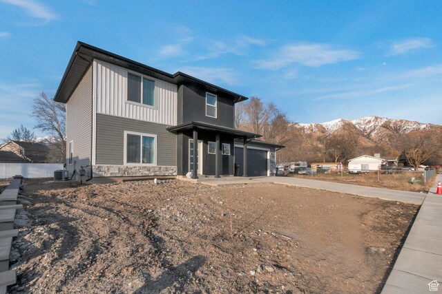 706 W 500 N, Brigham City, UT 84302 - rear view of house with fence, concrete driveway, central AC unit, stone siding, and a mountain view