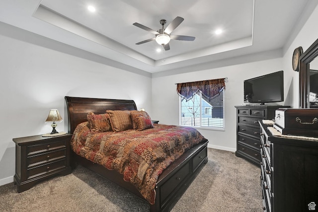 carpeted bedroom featuring recessed lighting, baseboards, a tray ceiling, and a ceiling fan
