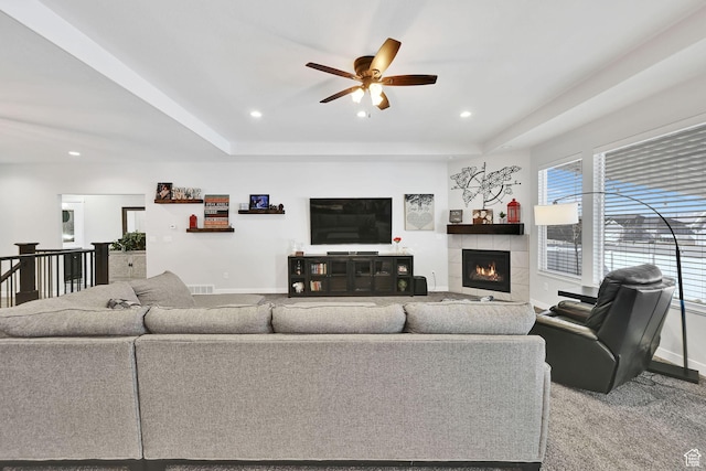 carpeted living area with recessed lighting, baseboards, a raised ceiling, and a fireplace