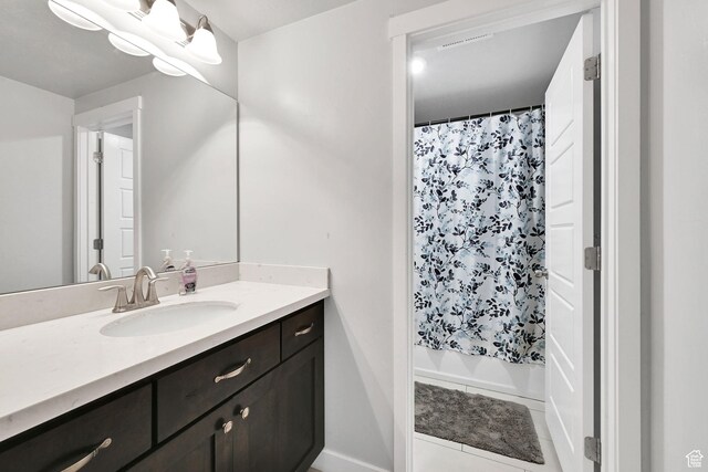 full bath with tile patterned floors, vanity, and shower / bath combo with shower curtain