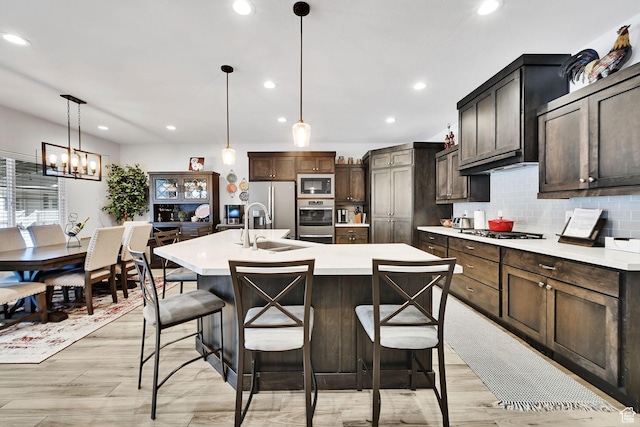 kitchen featuring built in microwave, a sink, light countertops, stainless steel fridge, and backsplash