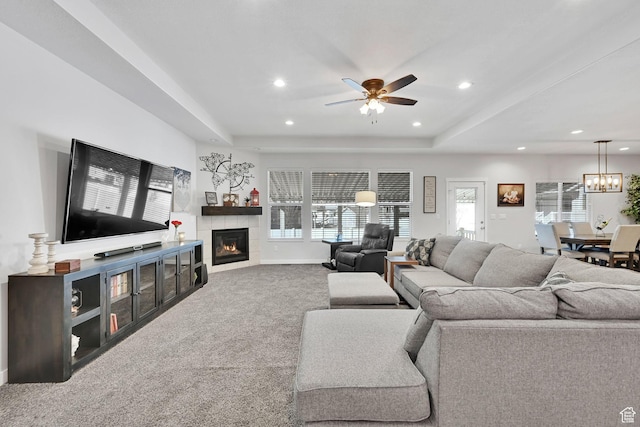 living area with recessed lighting, a fireplace, a tray ceiling, and carpet floors