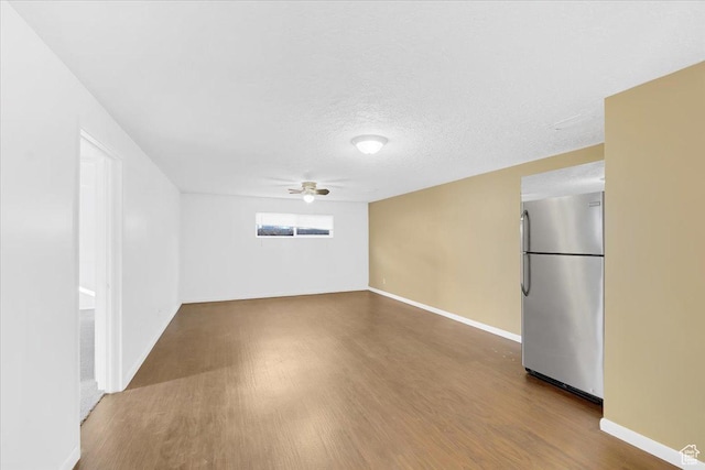 spare room with baseboards, wood finished floors, a textured ceiling, and ceiling fan
