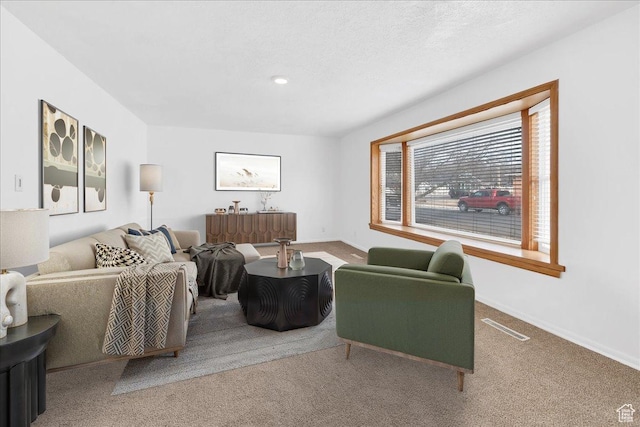 living room featuring carpet flooring, visible vents, a textured ceiling, and baseboards