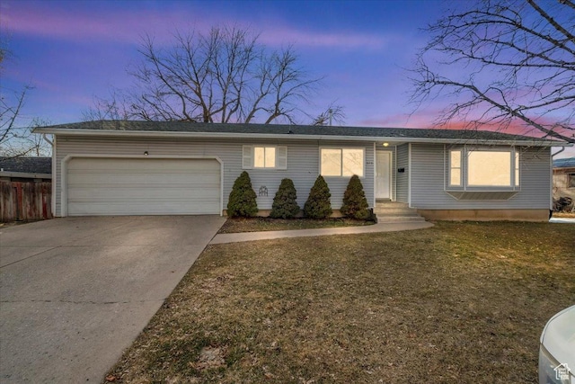 ranch-style home with a garage, a lawn, driveway, and fence
