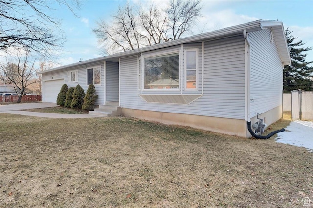ranch-style home featuring a front lawn, an attached garage, and fence