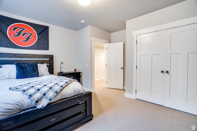 carpeted bedroom with a closet and baseboards