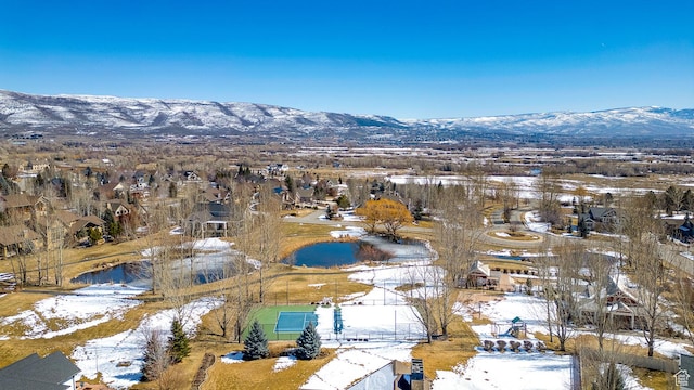 snowy aerial view with a residential view and a mountain view