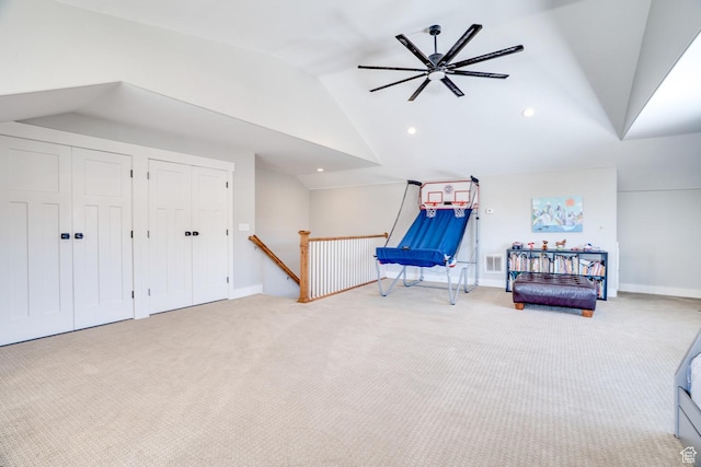 interior space featuring an upstairs landing, carpet floors, visible vents, lofted ceiling, and ceiling fan