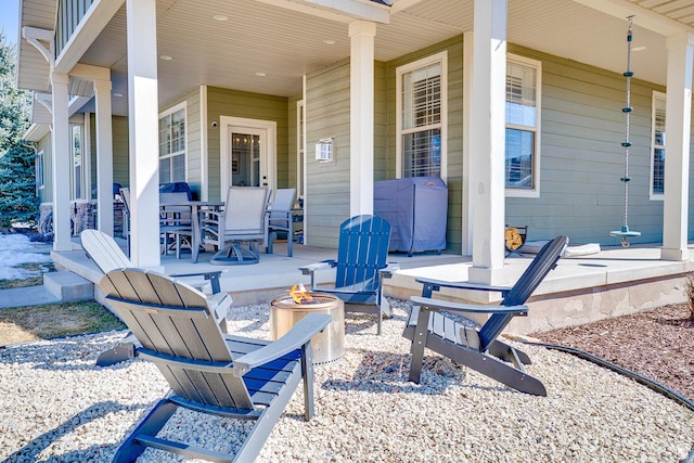 view of patio / terrace featuring a porch and a fire pit
