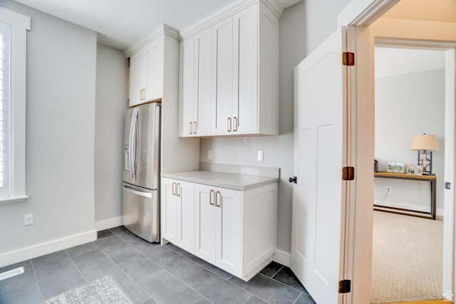 kitchen featuring a wealth of natural light, white cabinetry, visible vents, light countertops, and stainless steel fridge