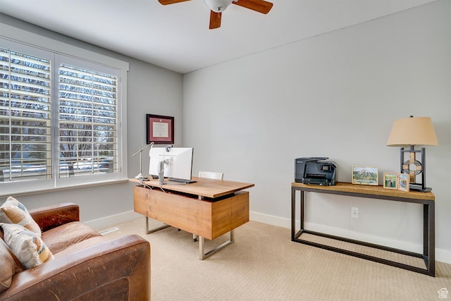 office space with light carpet, baseboards, and a ceiling fan