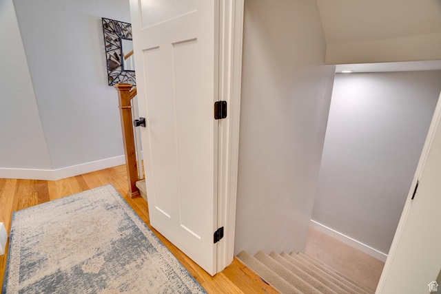 corridor with light wood-style floors and baseboards