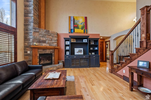 4048 W Ivy Ave, Mountain Green, UT 84050 - living area with a towering ceiling, light wood-style floors, a fireplace, and stairs