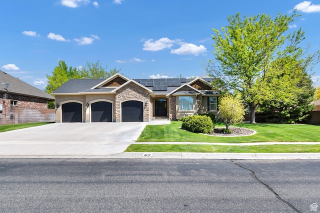 view of front facade with roof mounted solar panels, a front lawn, concrete driveway, and stone siding