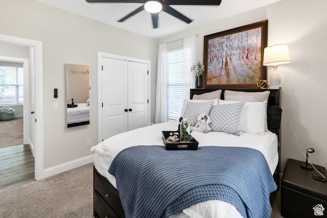 bedroom with carpet flooring, a closet, baseboards, and a ceiling fan