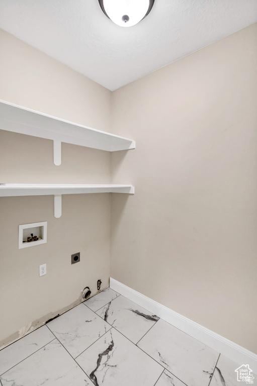laundry area featuring hookup for a washing machine, electric dryer hookup, light marble finish flooring, gas dryer hookup, and baseboards