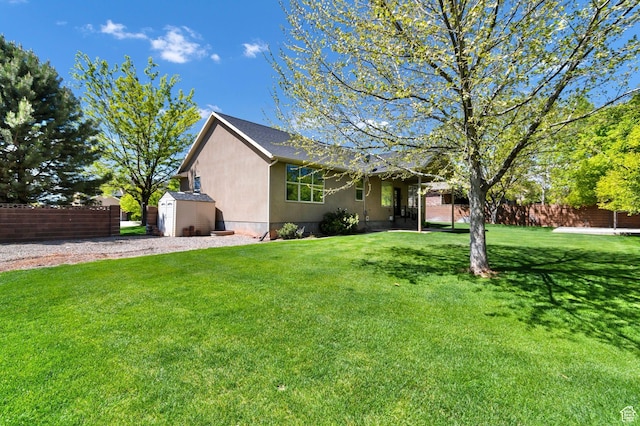 ranch-style house featuring a storage shed, an outbuilding, and stucco siding