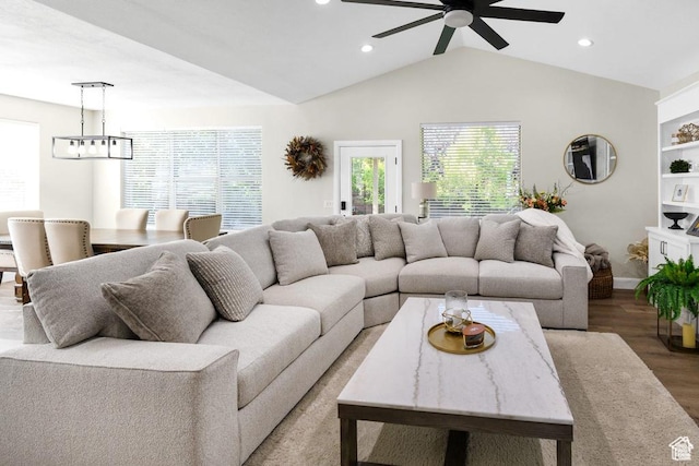 living area with a ceiling fan, wood finished floors, recessed lighting, vaulted ceiling, and baseboards
