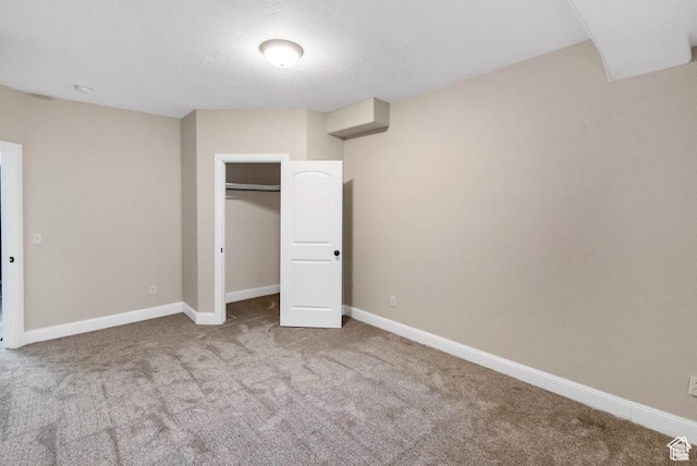 unfurnished bedroom featuring carpet floors, baseboards, and a closet